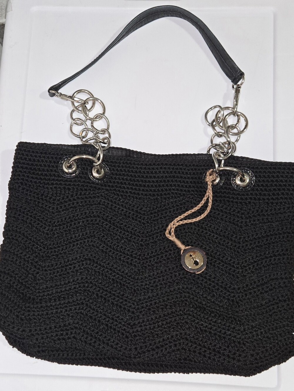 The Sak Black Crochet Shoulder Bag with Silver Chain Accents